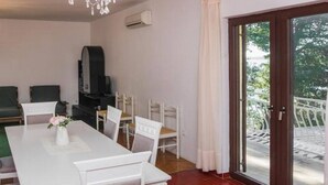 Un comedor con candelabro, televisión y una mesa con sillas.