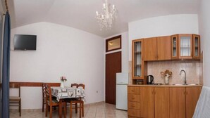 A compact living space with a dining area, kitchenette, and a bed. - Apartments Gaj Brodarica - A8 (Šibenik-Brodarica)