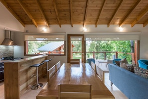 A spacious kitchen with wooden beams, a bar area, and a large dining table.