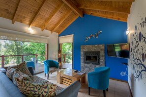 Bungalow superior | Área de sala de estar | Smart TV de 49 pulgadas con canales vía satélite, televisión y chimenea 
