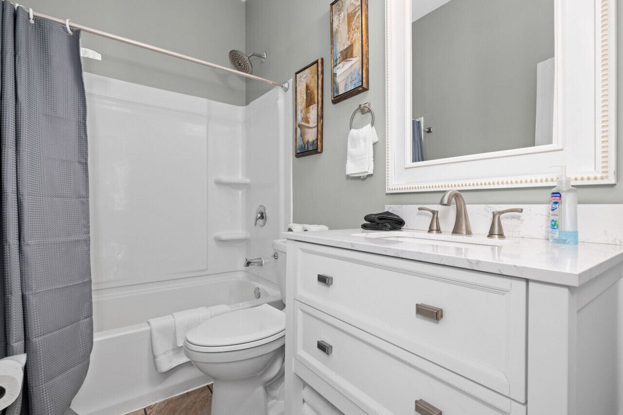 A modern bathroom with a bathtub, toilet, and vanity.