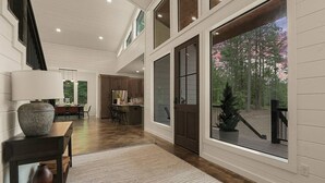 A spacious interior with a high ceiling, large windows, and a view of trees.