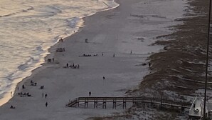 A beach with people walking and sitting, a pier, and the ocean. -   GULF FRONT 2 bed 2 bath 1700 sq ft with amazing amenities! 2 master king suite (Orange Beach)