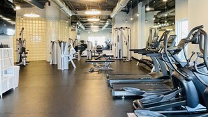 A gym with treadmills, weight machines, and a mirrored wall. -   GULF FRONT 2 bed 2 bath 1700 sq ft with amazing amenities! 2 master king suite (Orange Beach)