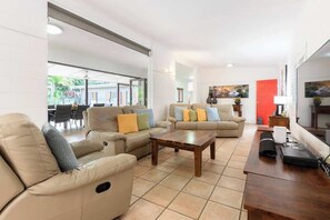 A living room with a sofa set, a coffee table, and a TV.