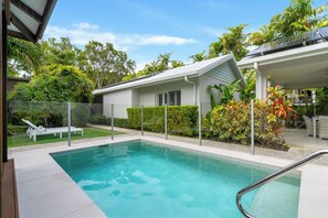 A modern house with a swimming pool, surrounded by lush greenery and a clear sky. - The Last Resort - Villa 1 (Palm Cove)
