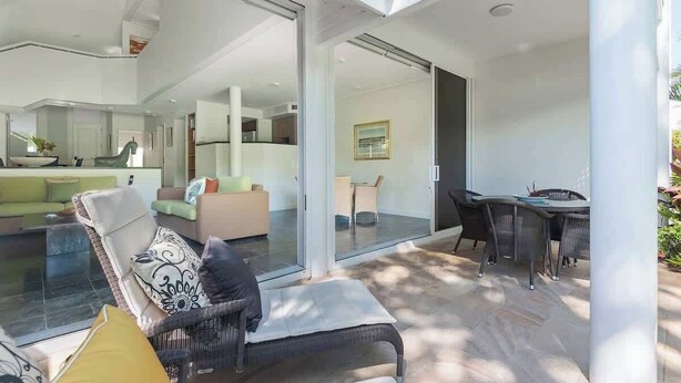 Un intérieur moderne comprenant un coin repas, un canapé et une porte vitrée donnant sur un espace extérieur.
