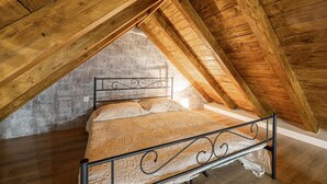 A single bed in a loft bedroom with a sloped ceiling and exposed wooden beams. - Nice home in Obrovac Sinjski with WiFi (Obrovac Sinjski)