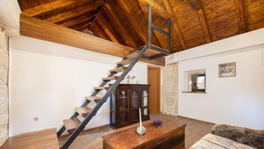 A rustic interior with a wooden staircase, a stone wall, and a wooden cabinet. - Nice home in Obrovac Sinjski with WiFi (Obrovac Sinjski)
