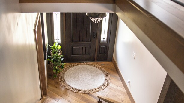 Un escalier en bois avec des rampes en métal menant à un palier.