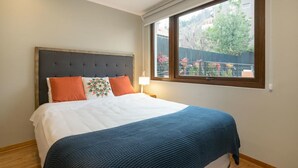 A bedroom with a bed, a window, and a view of the outside.