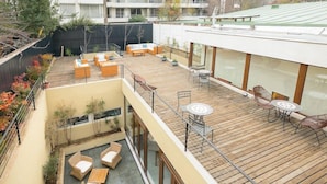 A multi-level outdoor deck with seating areas and a dining table. - Hotel Boutique Lambassade Bellavista (Santiago)