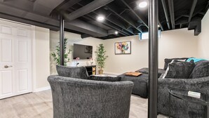 Un salon moderne avec des canapés gris, une table basse et une plante décorative.