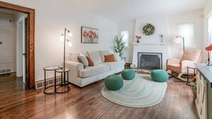 Un salon avec une cheminée, un canapé, une table basse et un lampadaire.