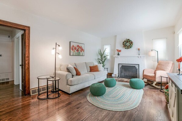 A living room with a fireplace, a sofa, a coffee table, and a floor lamp.