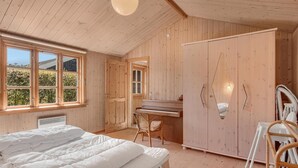 A wooden room with a bed, a piano, and a wardrobe. - Stunning home in Fårevejle with WiFi (Fårevejle)