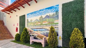 A building entrance with a mural, a staircase, and a pathway. - Baños del Inca Hotel (Baños del Inca)