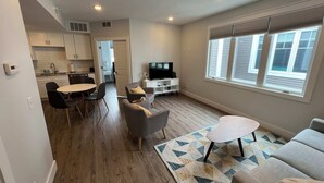 Un apartamento moderno con comedor, sala de estar y pequeña cocina.