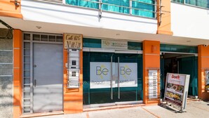 A hotel entrance with a sign reading "Be Be" and a contact number. - Ayenda 1067 Bogota Elite (Bogotá)