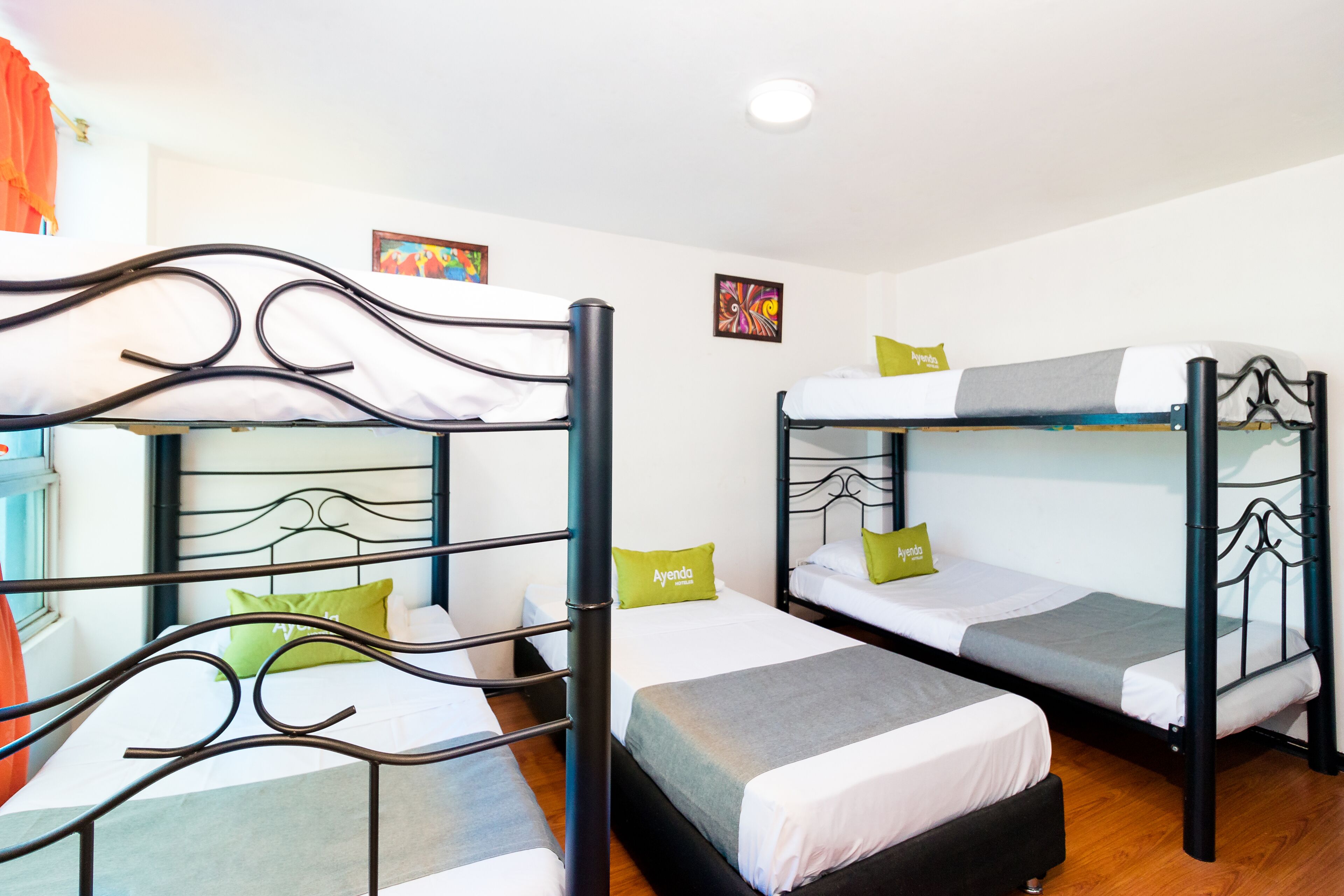 A room with three bunk beds, each with a pillow and a blanket.