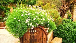 A rustic wooden barrel with 'Ristorante Camere' written on it, surrounded by greenery and rocks. - Agriturismo L'uliveto (Reitano)