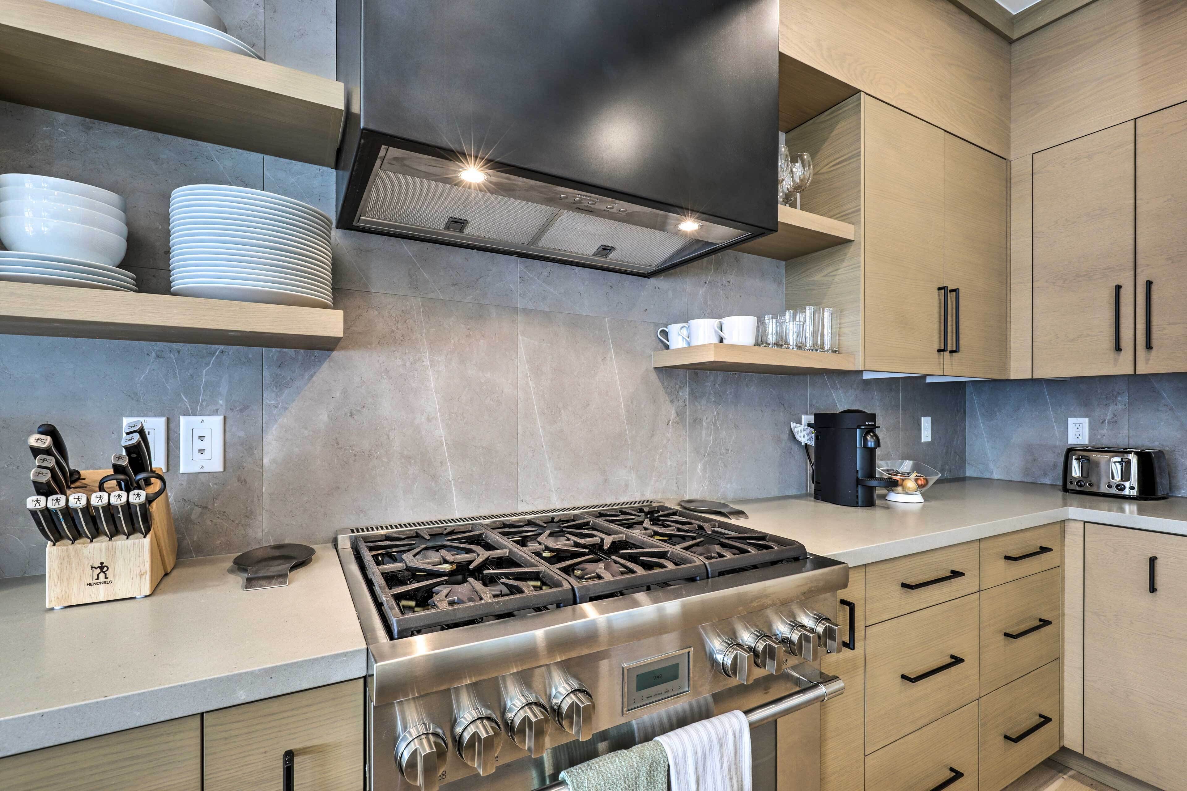 Una cocina moderna con estufa a gas, armarios de madera y cafetera.