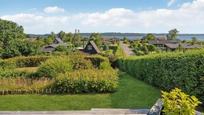 A residential area with houses, a grassy path, and a body of water in the background. - Nice home in Børkop with WiFi (Børkop)