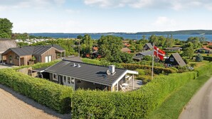 A residential area with houses, a flag, and a view of the water. - Nice home in Børkop with WiFi (Børkop)