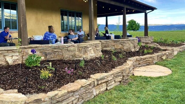 A covered outdoor seating area with stone walls and a stone pathway.