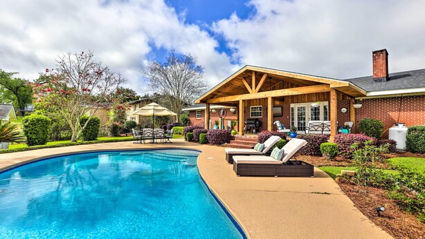 A swimming pool with lounge chairs and a covered patio area. - Sunny Florida Abode - Patio, Pool, & Fire Pit (Marianna)