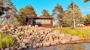 A cabin with a wooden exterior, a window, and a small porch area.