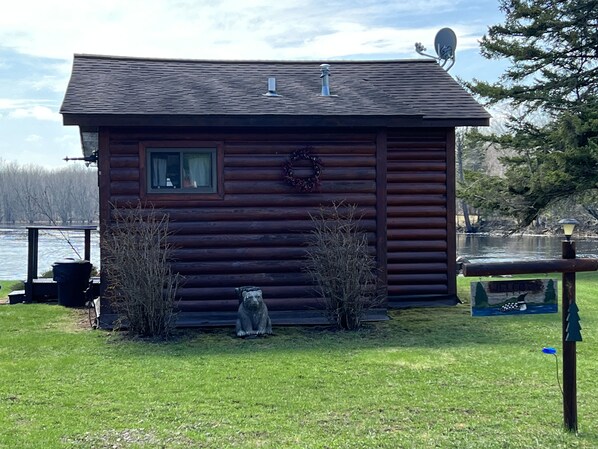 A small wooden cabin with a window, a wreath, and a sign that reads "Welcome". - EAGLE LODGE - Cozy Cabin Overlooking the Beautiful E. Fork of the Chippewa River (Loretta)