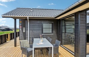A modern outdoor patio with a table and chairs, a window, and a view of the surrounding area. - Pet friendly home in Hjørring with WiFi (Hjørring)
