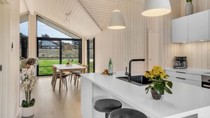 A modern kitchen with a large island, white cabinetry, and pendant lighting. - Pet friendly home in Hjørring with WiFi (Hjørring)