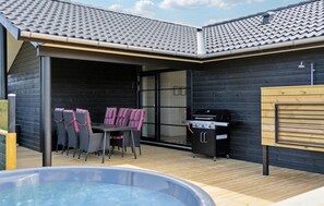 A covered outdoor area with a hot tub, a barbecue grill, and a dining table with chairs. - Pet friendly home in Hjørring with WiFi (Hjørring)