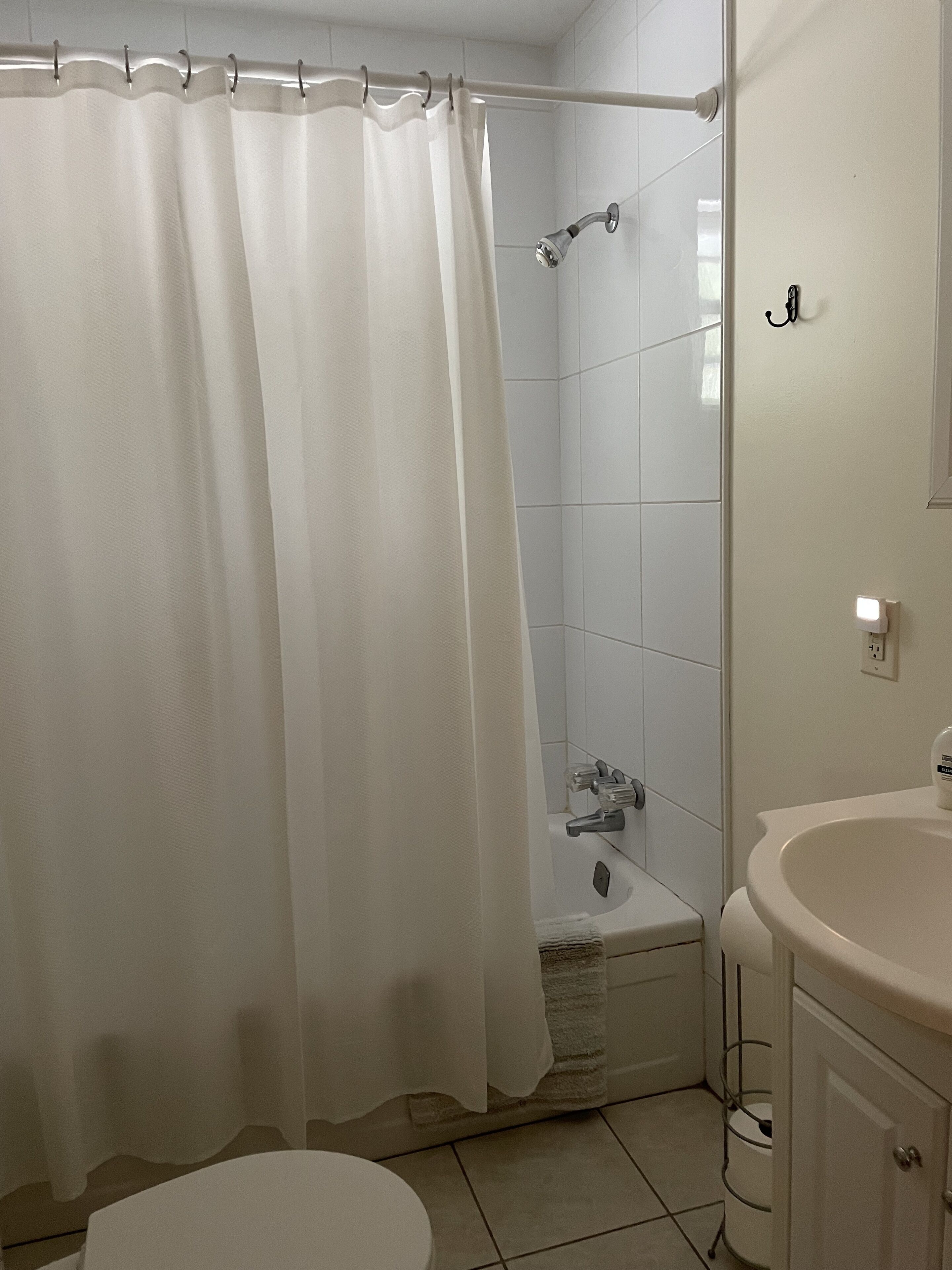 Un baño con ducha, inodoro y lavamanos.