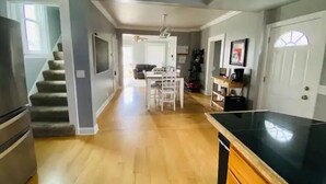 A kitchen with a black countertop, wooden cabinets, and a dining area with a white table and chairs. - 3bed 2bath nestled in cozy Grandview neighborhood (pet friendly!) (Dubuque)