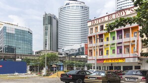 Un edificio de varios pisos con un letrero llamativo que dice 'Hotel Buddy's'.