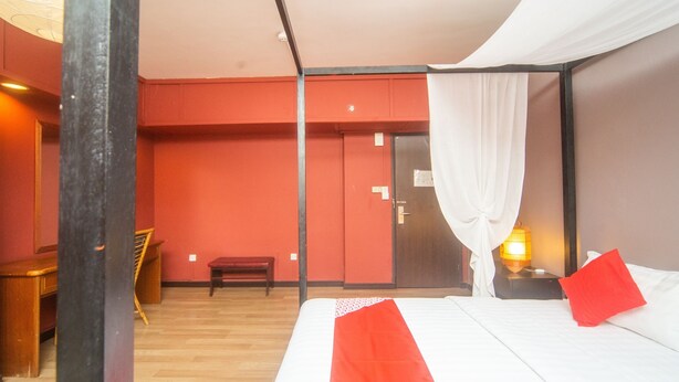 Una habitación de hotel con una cama, un escritorio y una silla.