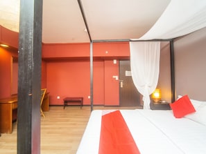 A hotel room with a bed, a desk, and a chair. - OYO 327 Buddys Hotel (Kuala Lumpur)