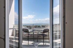 A balcony with two chairs and a view of a cityscape and mountains. - White Panoramic Retreat (Cagliari)
