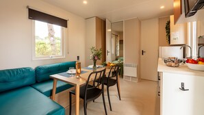 Een moderne kitchenette met een inbouwoven, een spoelbak en een aanrecht.
