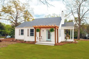 A house with a covered porch, a front door, and a small garden area.
