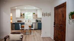 A modern kitchen with white subway tiles, a wooden dining table, and chairs. - Beautifully Renovated and Decorated Home in Great Neighborhood (Augusta)