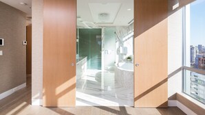 A modern hotel room with a large sliding door leading to a bathroom with a marble floor and a large bathtub. - Luxurious Penthouse in Trendy Yaletown with Private Rooftop Pool (Vancouver)