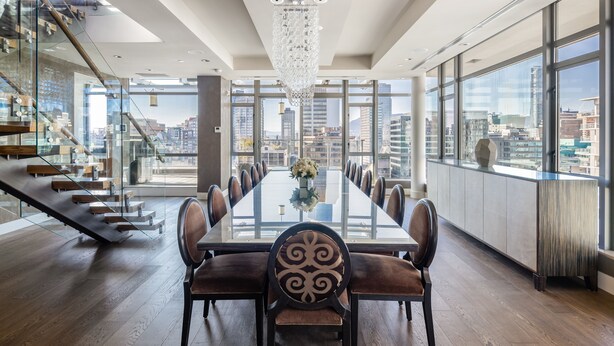 A modern dining area with a long table, chairs, and a chandelier. - Luxurious Penthouse in Trendy Yaletown with Private Rooftop Pool (Vancouver)