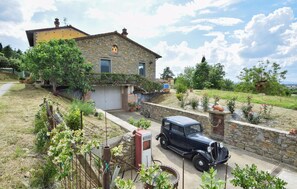 A stone house with a car parked in front.