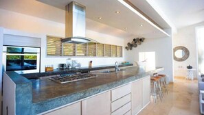 A modern kitchen with a large island, built-in appliances, and a sleek design. - Boutique-style villa with 3-level Cascading Pool (Cabarete)
