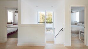 Ein geräumiger Raum mit großem Fenster, einer Wendeltreppe und einem separaten Schlafbereich.
