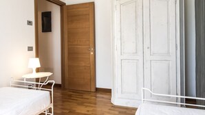 A bedroom with a wooden door, a white wardrobe, a bedside table with a lamp, and a bed. - M348 - Marcelli, comfortable new three-room apartment with swimming pool and bal (Numana)